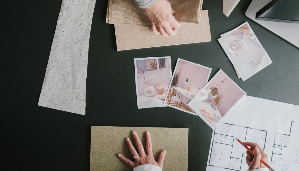 Designer reviewing custom home floor plans with tile and flooring samples during the interior design and selections process.